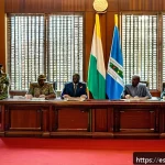 시에라리온 정부 구조 - A detailed scene of Sierra Leone&rsquo;s presidential office interior during a policy meeting, featuring t...